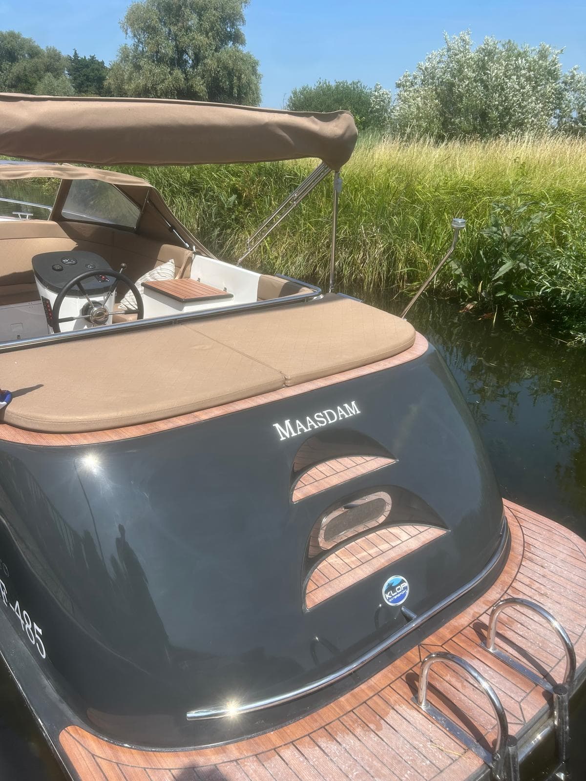Grijze sloep Maasdam aan de kant met teakdek, na behandeling
